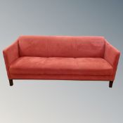 A Scandinavian three seater settee in red fabric