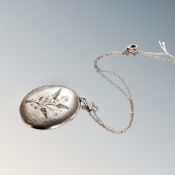 A large silver locket etched with flowers and ferns, Birmingham hallmarks, on sterling silver chain,