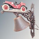 A cast iron bell on vintage car wall bracket.