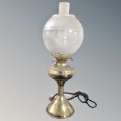 A vintage brass oil lamp with chimney and shade, electrified.