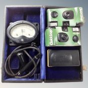 A boxed GEC voltmeter together with two disposable cameras.