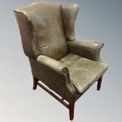 A 20th century Georgian-style studded green leather wingback armchair