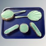 A five-piece silver and green guilloche enamel dressing table set.