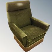 A mid century fireside chair in green fabric