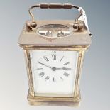 A brass cased carriage timepiece with platform escapement and key.