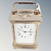A brass cased carriage timepiece with platform escapement and key.