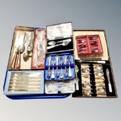 A tray containing a collection of assorted flatware, boxed and unboxed.