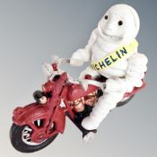 A cast iron figure, Michelin man on motorbike.