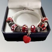 A boxed charm bracelet by Rhona Sutton with six marked glass and silver Pandora beads.