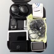 A tray containing mobile phones including Samsung, a wifi booster,