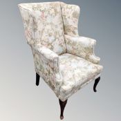 A 20th century Georgian-style wingback armchair in floral fabric