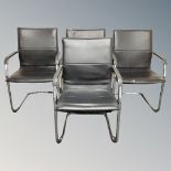 A set of four tubular metal office armchairs upholstered in black leather.
