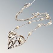 A sterling silver Art Nouveau style heart and flowers pendant on silver and pearl chain.