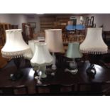 A pair of contemporary table lamps with tasseled shades together with four further ceramic table