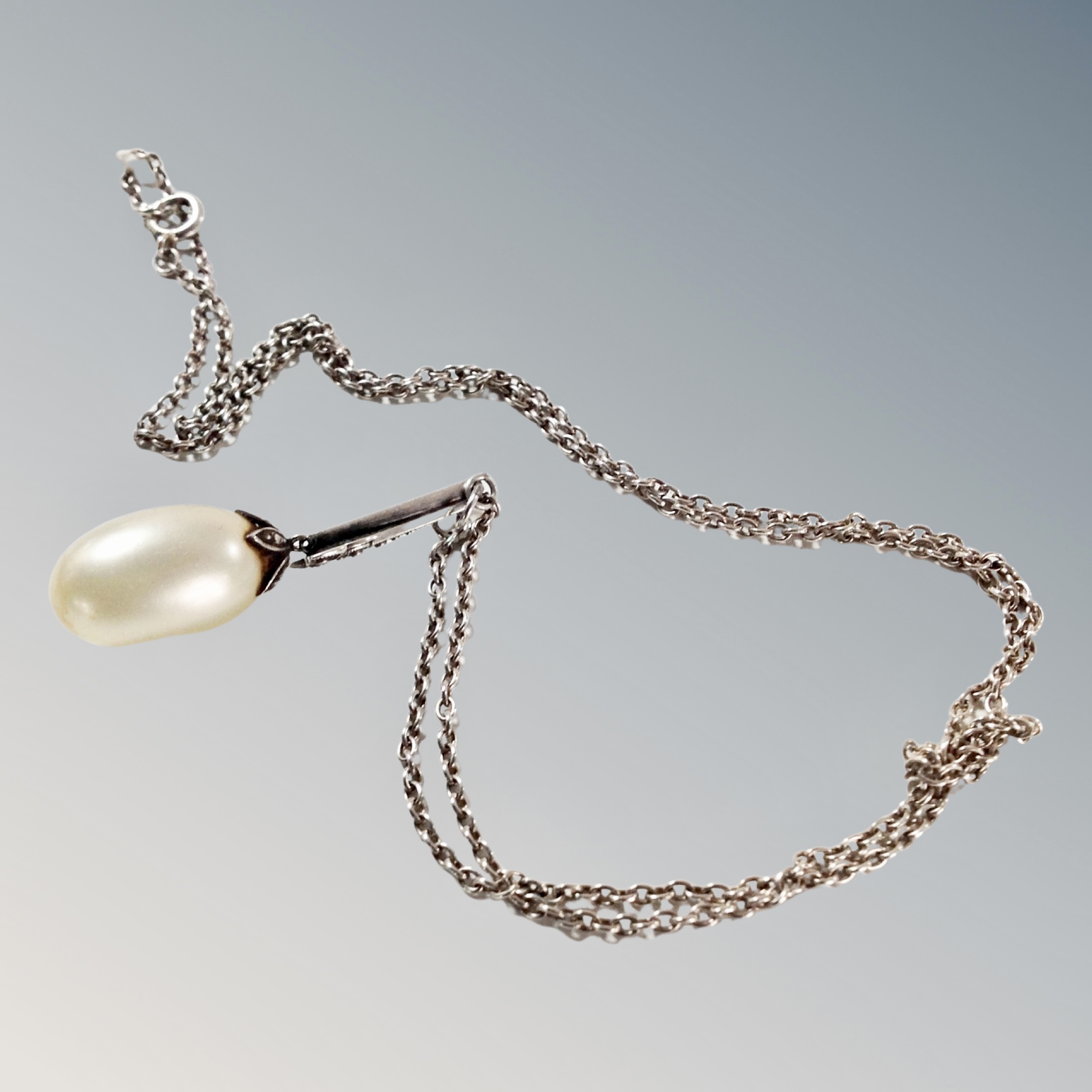 A Baroque teardrop pearl in an Art Deco setting on sterling silver chain, 7.9g gross.