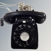 A vintage black dial telephone with plug insert.