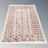 A Tekke rug, Afghanistan, with repeat gul motif on cream ground, 190cm by 129cm.