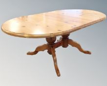An oval pine twin pedestal dining table with leaf together with a set of six chairs