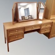 A teak G-plan five drawer kneehole dressing table with triple mirror