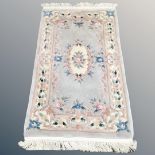 A Chinese embossed fringed rug,
