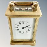 A brass cased carriage timepiece with platform escapement and white enamel dial.