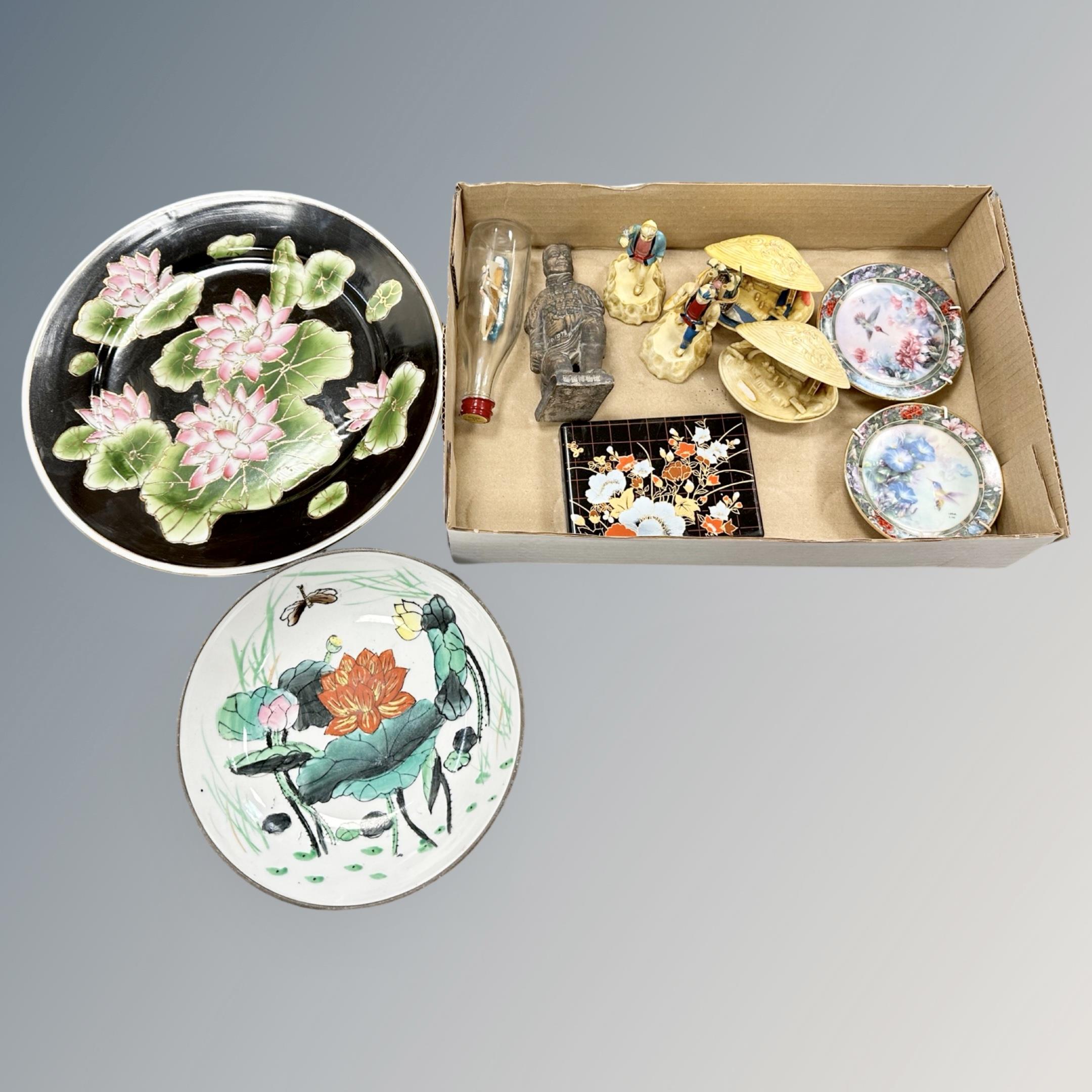 Two oriental plates and a box containing similar figures,