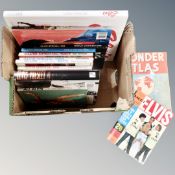 A box containing 12 annuals and books relating to Elvis Presley together with a World Atlas.