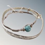 A small white metal bangle with turquoise bead together with a large adjustable sterling silver