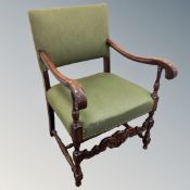 A 20th century carved oak open armchair in green fabric