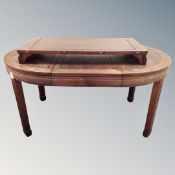 A Chinese hardwood circular extending dining table with two leaves