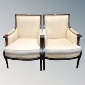 A pair of carved beech framed French baroque style armchairs in golden fabric