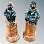 A pair of Franz Bergman coal-painted bronze figures of seated Arab children, upon later mottled,