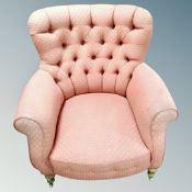 A 19th century buttoned back armchair in pink fabric