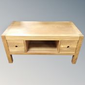 A contemporary oak two tier coffee table fitted drawers on raised legs 55 cm x 60 cm x 117 cm.
