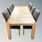 A contemporary oak dining table with extension leaf together with a set of eight high backed