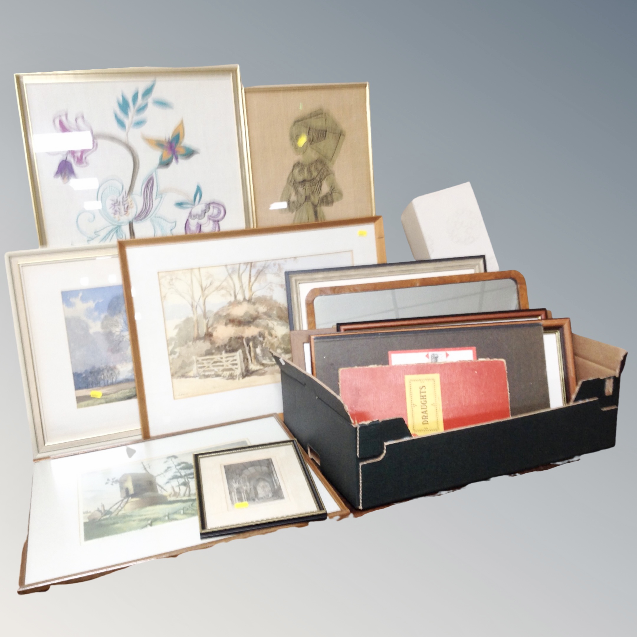 A box of pictures and prints, needle work panel, framed mirror, wooden table lamp,