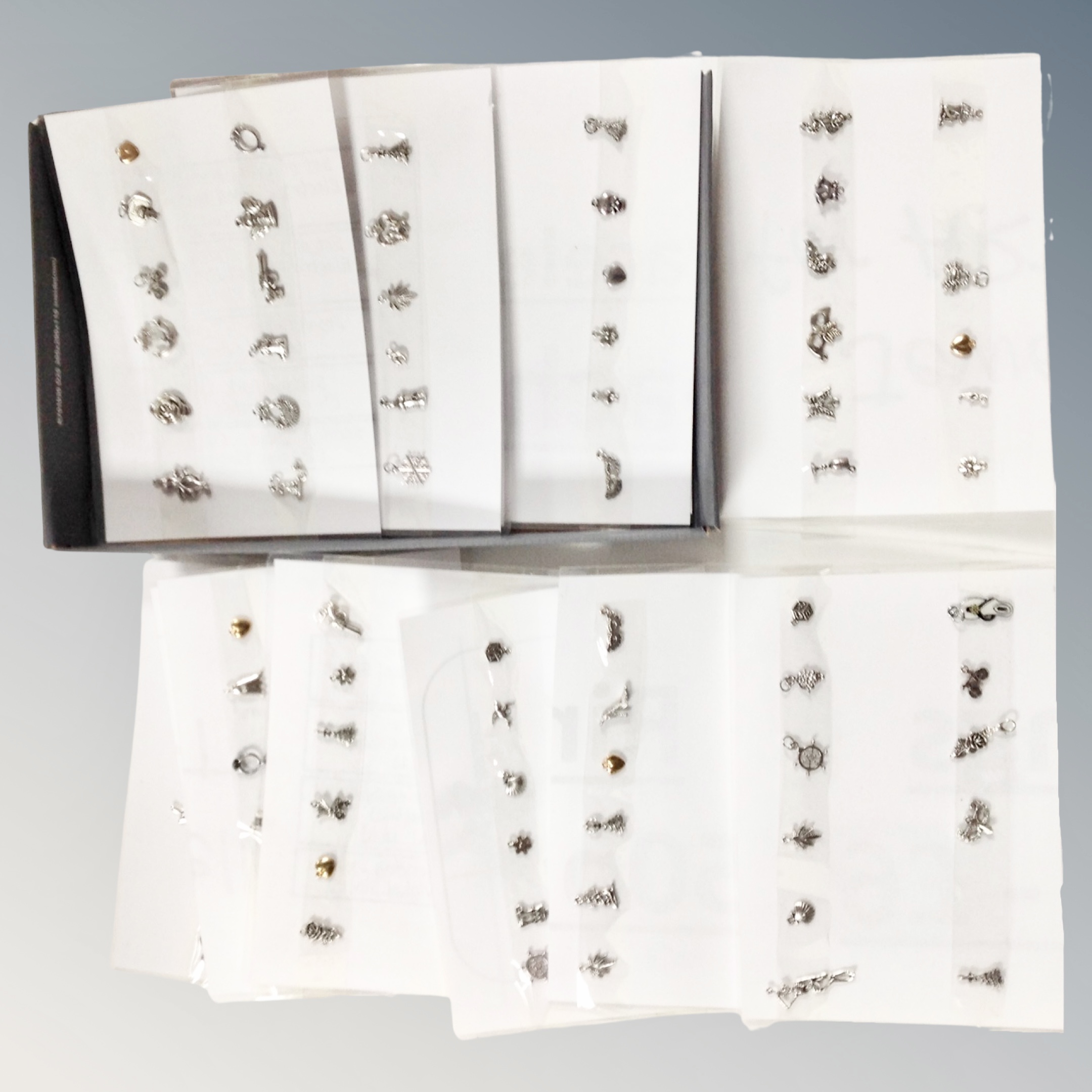A quantity of bracelet charms mounted on card