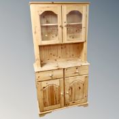 A pine double door kitchen dresser fitted with drawers beneath