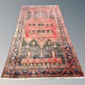 A Kurdish Long Rug, North-West Iran, the charcoal and madder central field with tribal motifs,