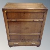 A 1930's oak fall fronted storage cabinet