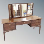A Stag Minstrel five drawer dressing table on raised legs with triple mirror