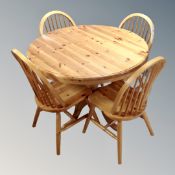 A circular pine pedestal kitchen table together with a set of four spindle backed chairs and two