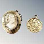 A 9ct gold circular pendant marked 'TG' and a cameo brooch in yellow metal mount, unmarked.