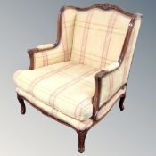 A French style carved beech armchair in yellow checkered fabric