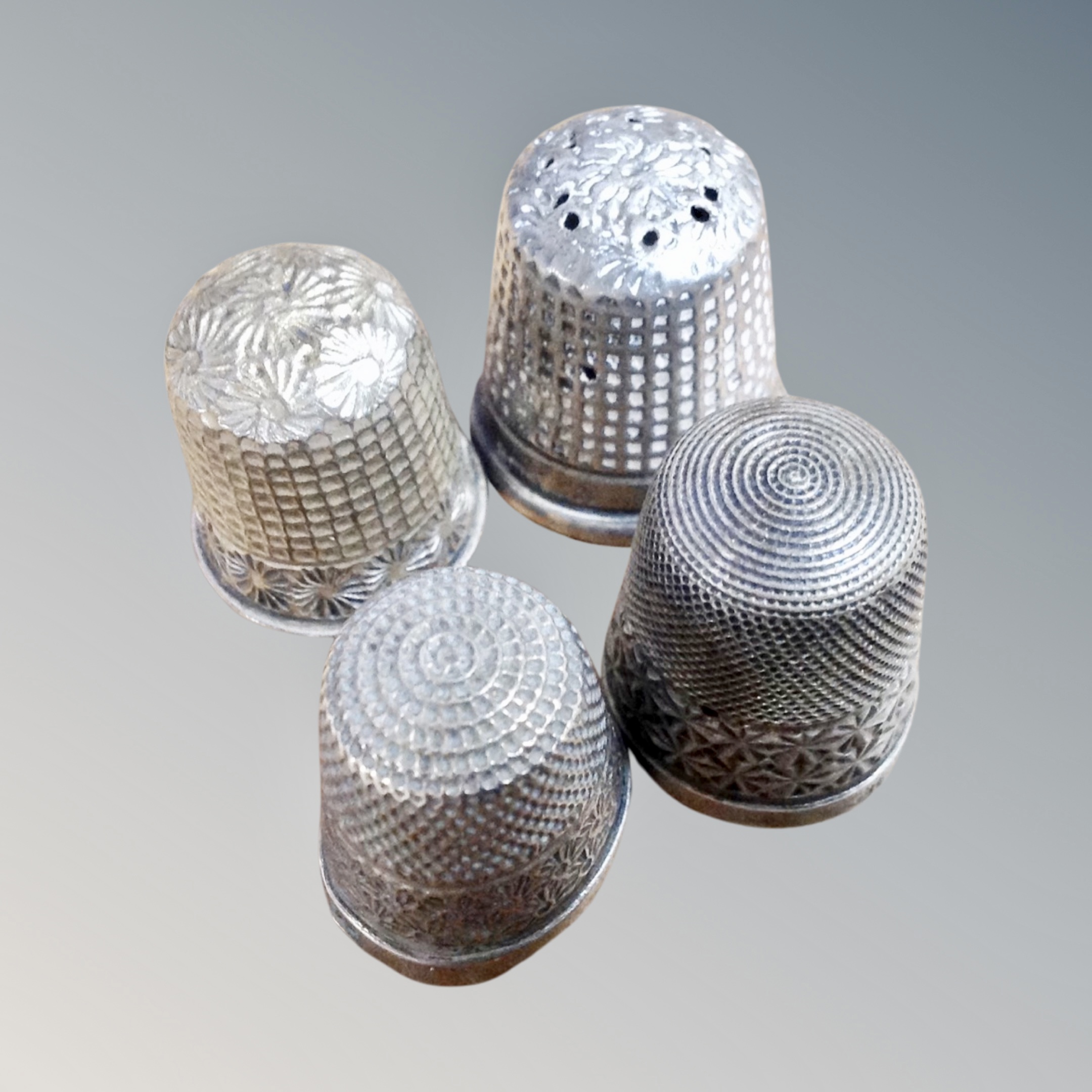 Four hall marked silver thimbles,