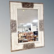 A contemporary over mantel mirror in faux stone effect frame