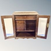 A later 19th century double door oak smoker's cabinet.