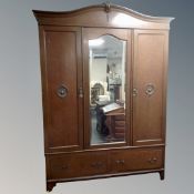 A 19th century oak triple door wardrobe with central mirrored door