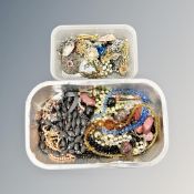 A crate containing costume jewellery, brooches,