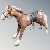 A fibre glass display horse with leather saddle